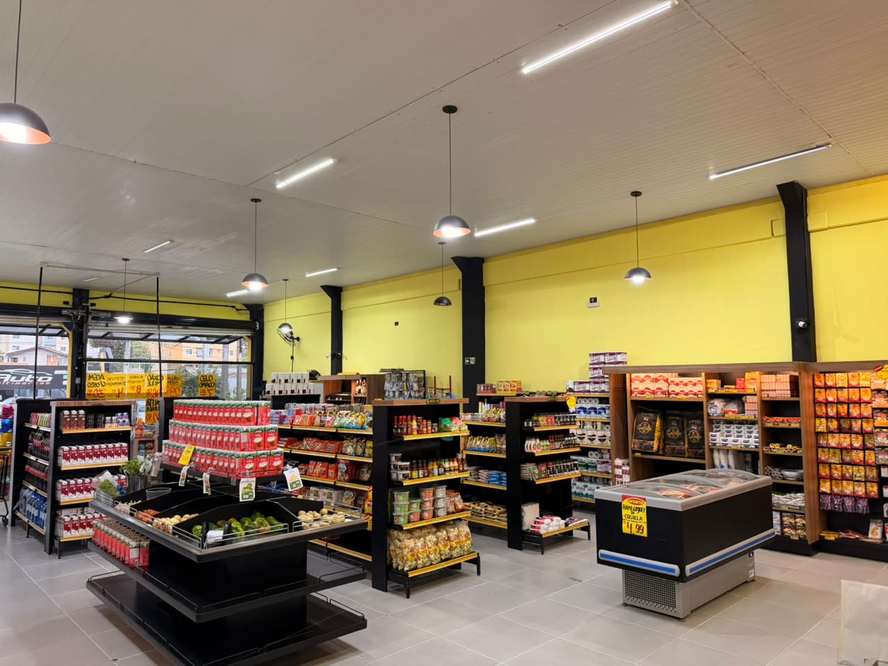 Banca de hortifrúti e ilha de congelados no centro do salão
